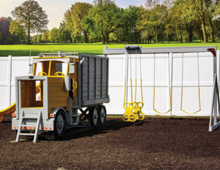 yellow dump truck swing set sitting in a bed of mulch