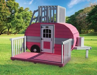 pink and gray small camper swing set in a grassy field