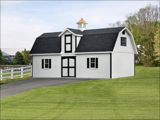 a white and black backyard barn that's been convereted into a house