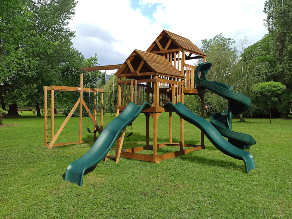 wooden playset with three green slides