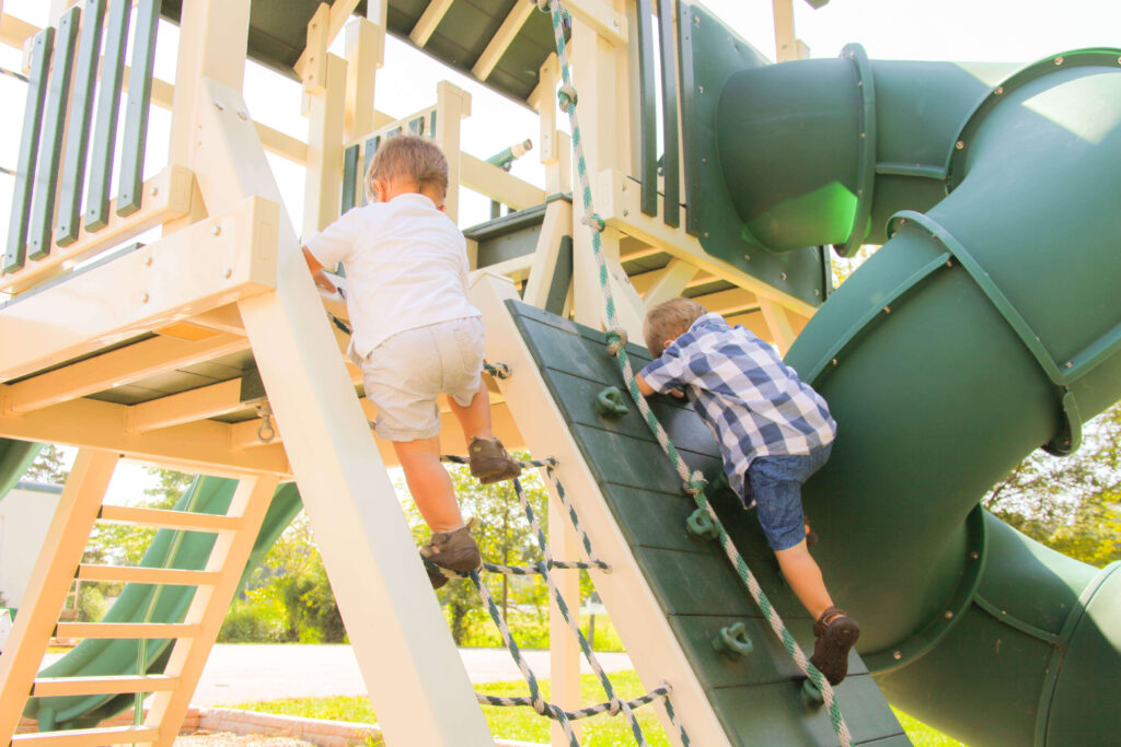 two kids climbing on a playground